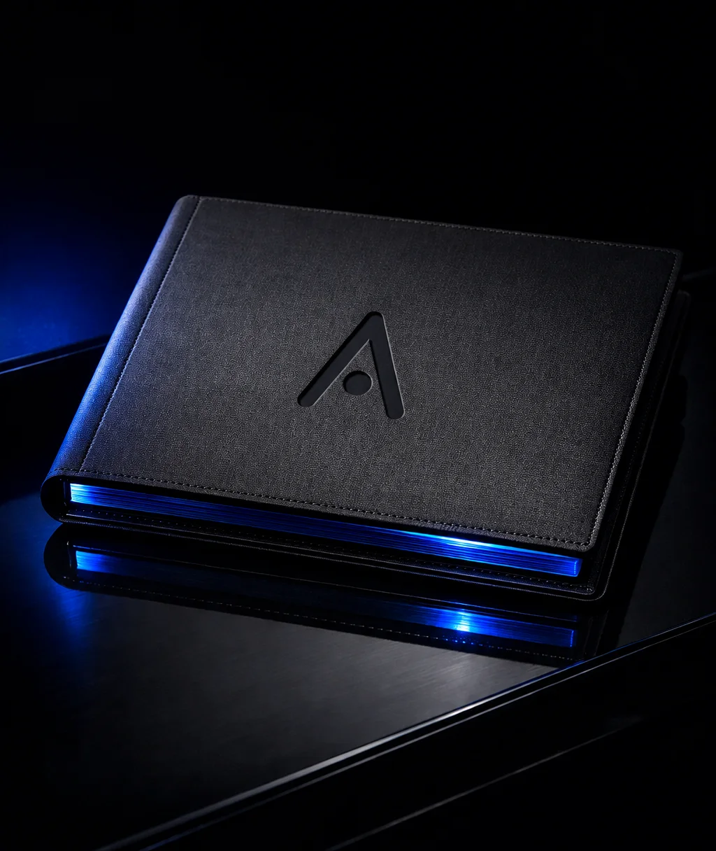 A matte black document folio embossed with the Atvora mark, its page edges glowing blue on a dark surface
